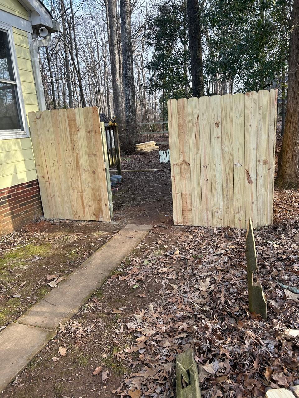 Two new wood privacy gates beside a house